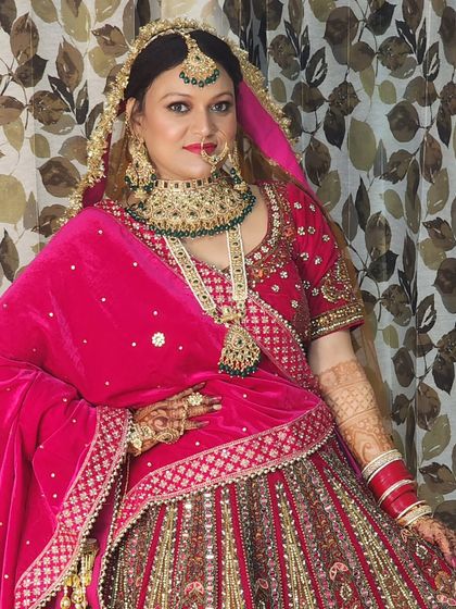 A full portrait of a bride in her stunning pink ensemble. The makeup is balanced to enhance her features without overpowering her natural beauty.