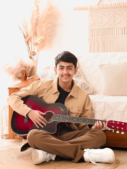 Strumming a quiet tune. This portrait, with its warm, earthy tones, captures a calm and thoughtful moment with a young guitarist.