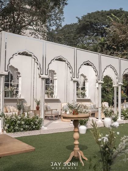 Another perspective of the expansive ivory-themed lounge, showing the thoughtful distribution of seating areas across the lawn to create multiple zones for conversation.