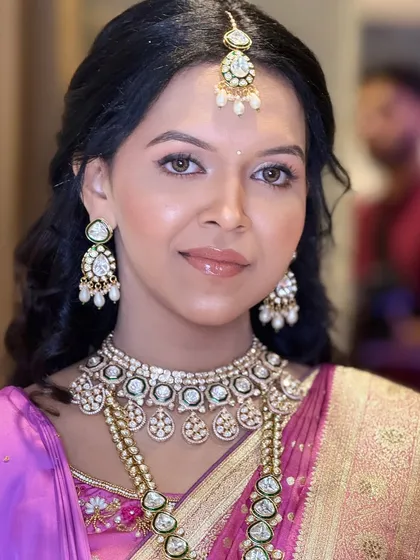 A stunning portrait from her engagement day. The neutral-toned makeup with a glossy lip complements her vibrant purple saree and polki jewelry perfectly.