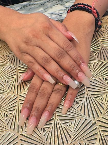 Extra-long, clear coffin nails with a very subtle nude ombre effect. This minimalist design is perfect for a clean and sophisticated look.