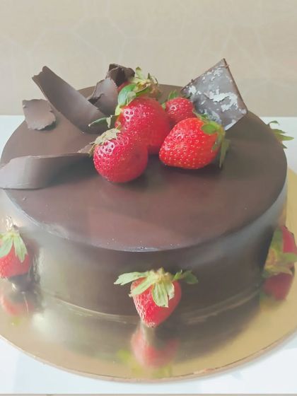 A simple yet decadent chocolate truffle cake adorned with fresh strawberries. A classic choice for any celebration.