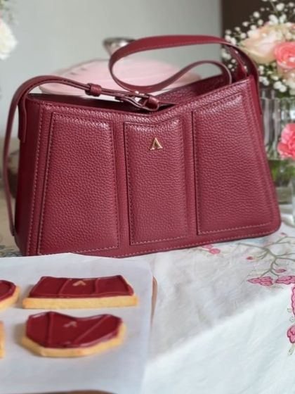 A side-by-side look at the inspiration and the creation. We worked hard to capture the unique texture and shape of the brand's leather handbag in our custom sugar cookie design.