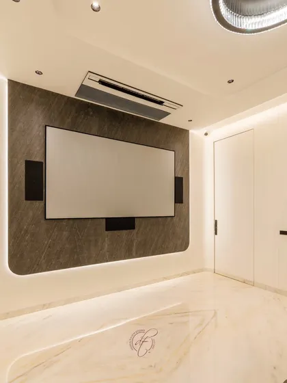 The projection screen is the star of the show, mounted on a sophisticated back-lit wall that creates a captivating focal point. The design is both modern and luxurious.