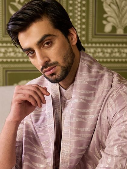This mystic mauve kurta set, complete with a matching stole, offers a unique and sophisticated color choice. The subtle woven pattern in the fabric adds a layer of texture.
