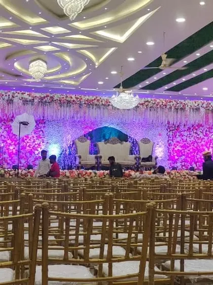 The Akshata banquet hall in Nerul, set up for a grand event. The ceiling has unique green panels, and the stage is lavishly decorated with flowers.