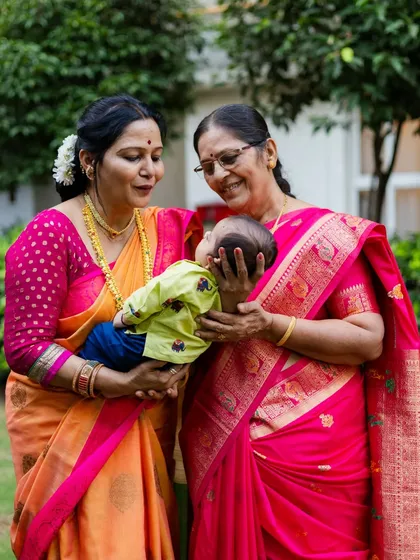 The bond between generations is truly special. Here, a grandmother and great-grandmother share a loving moment with the newest member of the family during his naming ceremony, a priceless memory for everyone.