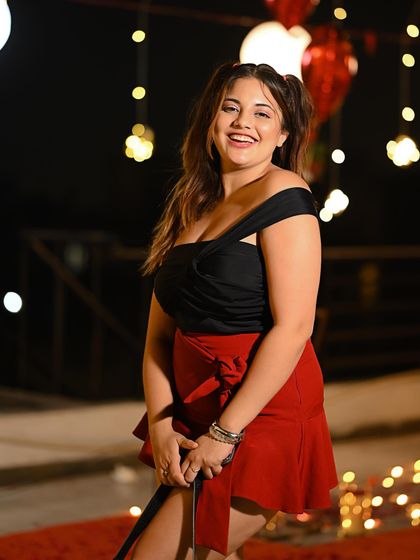 A joyful and candid shot from a rooftop party setup, complete with fairy lights and balloons.