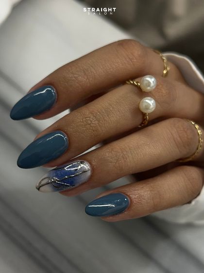 A close-up of the beautiful marble and silver leaf accent nail. The free-flowing design mimics natural stone, creating an elegant and organic look.