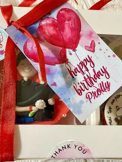The final presentation of our Nutella hazelnut bento and cupcake box, tied with a red ribbon and a custom 'Happy Birthday' tag. It’s all about those little details that make a gift special.