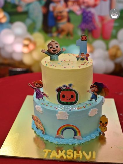 The full setup of the Cocomelon cake at the birthday party. It fits perfectly with the colorful decorations and happy theme.