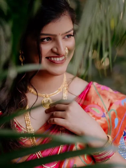 A beautiful, candid shot of a bride in a Paithani saree. The makeup is kept natural and glowing, letting the richness of the saree and her smile be the highlights.