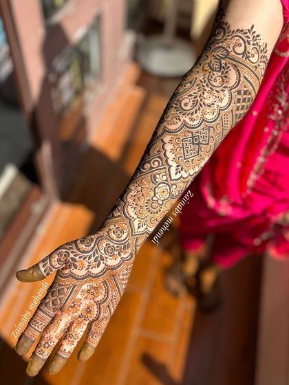 Another angle of Anam's intricate full-arm henna, showcasing the beautiful flow of the design.