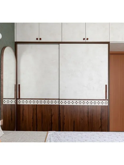 The parents' bedroom features a sliding wardrobe with a mix of materials. The lower half is dark wood with traditional tile-like details, while the upper half has a light, textured finish.