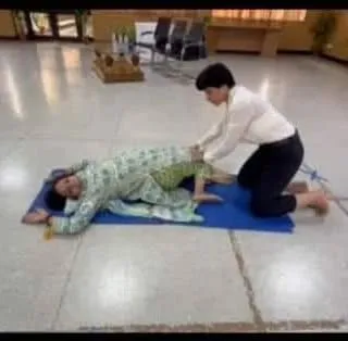 Demonstrating a simple stretching exercise during the workshop to help relieve back pain and improve flexibility for the teachers.