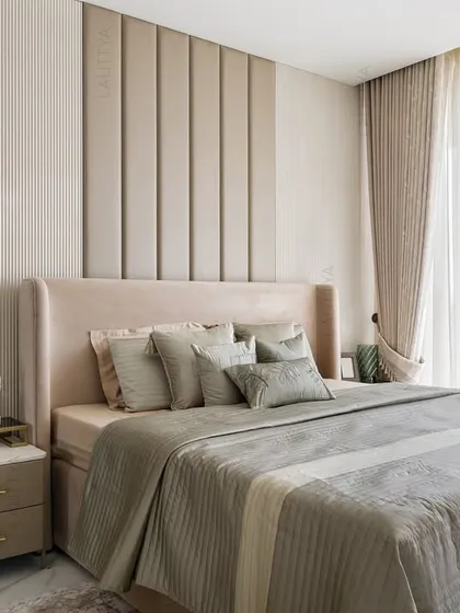 A serene view of the daughter's bedroom, focusing on the plush upholstered headboard set against a wall of vertical panels. The soft, neutral bedding and sheer curtains create a cocoon of calm.