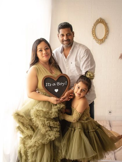 A beautiful family portrait announcing "It's a Boy". The coordinating olive green outfits for mother and daughter are a lovely touch.