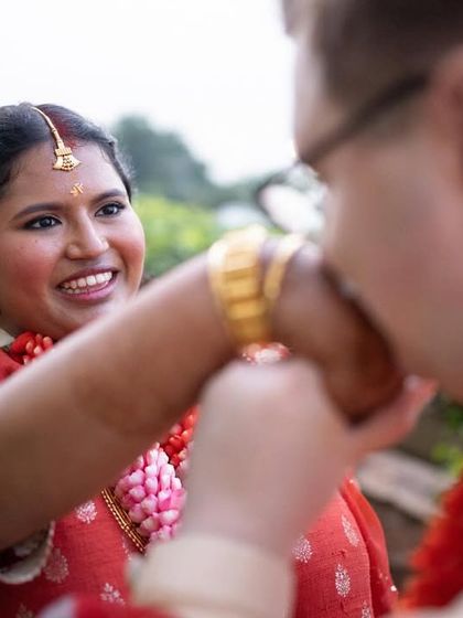 A sweet moment from an Indian-American wedding, blending traditions with a gentle kiss on the hand.