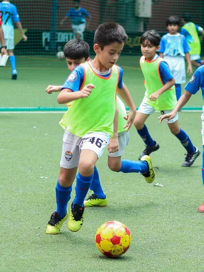 A player skillfully maneuvering the ball through opponents during an intense training game.