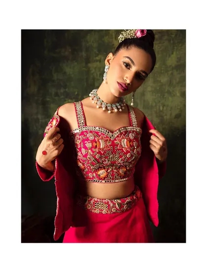 This vibrant pink lehenga with a modern, embellished bustier is perfect for a day wedding or Mehendi. I styled it with a simple necklace to let the outfit's bright color and detailed embroidery shine.
