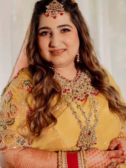 Capturing the joy of this bride's wedding ceremony. Her makeup is traditional and radiant, with warm tones and defined eyes, paired with soft waves for a look that is both classic and effortlessly beautiful.