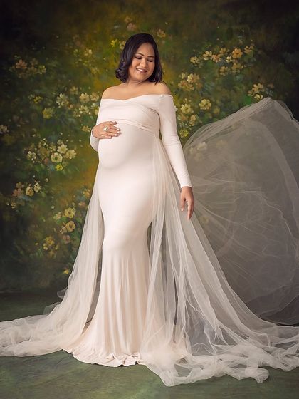 The gentle toss of the gown's train adds a dynamic and graceful element to this beautiful solo maternity portrait.