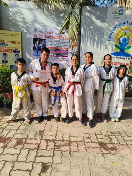 A group of my students of various ages and belt ranks posing for a photo after a training session.