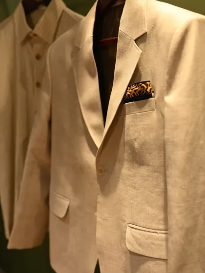 A classic beige blazer, perfect for a sophisticated daytime wedding event. The subtle texture and clean lines, paired with a patterned pocket square, create a look of modern elegance.
