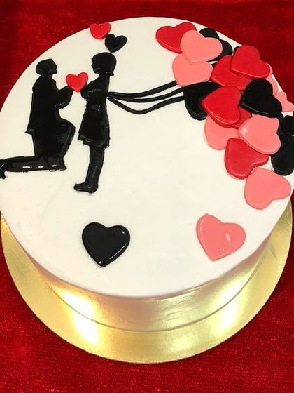 Another view of the romantic silhouette cake, showcasing the clean white canvas that makes the black and red details pop.