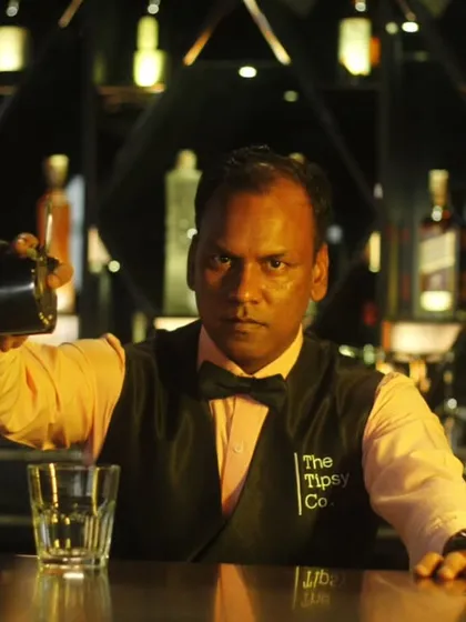 Our bartender pours with intense focus, serving up what we call 'Liquid Drama'. This image captures the serious craft and passion that goes into every single drink we make.