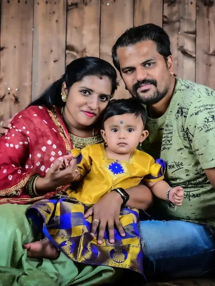 This family portrait, set against a rustic wooden backdrop, showcases a beautiful blend of traditional clothing and relaxed, happy expressions. It’s a snapshot of their life and love.