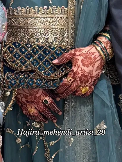 My henna work complementing a bride's complete look. The rich floral stain on the hands looks stunning against the deep blue and gold of the wedding attire and accessories.