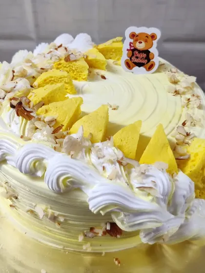 A butterscotch cake with a crunchy texture. This cake is decorated with butterscotch chips and sliced almonds.