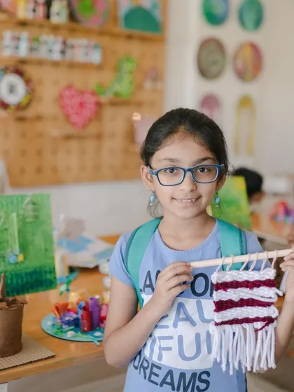 This young artist is holding up the beautiful tapestry she created during a weaving session at our art camp. The combination of colors and textures is just wonderful.
