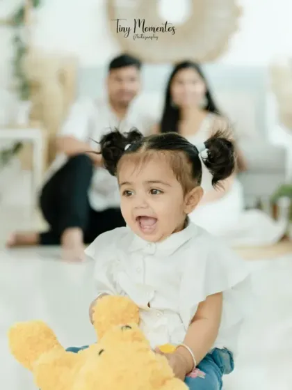 A perfect family moment, with this little girl's infectious giggle taking center stage while her loving parents watch on in our boho-styled studio.
