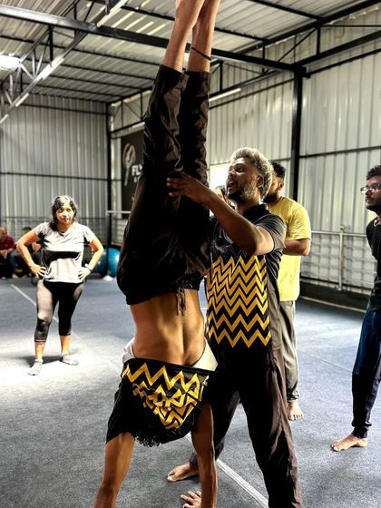 During a workshop, I provide hands-on assistance to an adult student working on his handstand alignment.