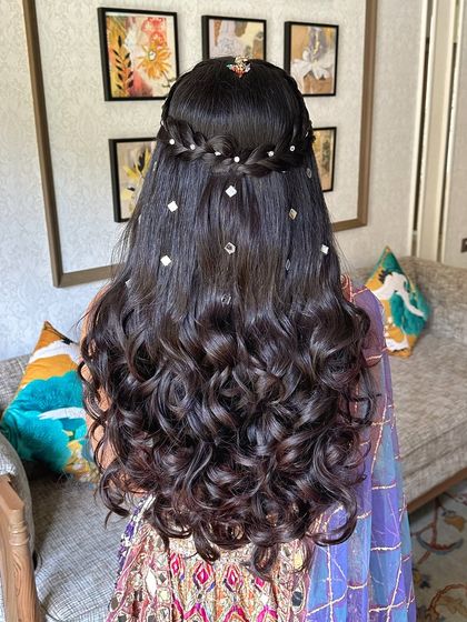 The back view of the half-up style with curls and mirror work, a creative way to incorporate elements of the outfit into the hair.