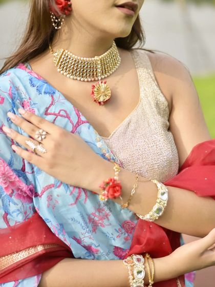 A detailed shot of my Janmashtami jewelry. The focus is on the gold choker, floral hand jewelry, and bangles that complete the festive look.
