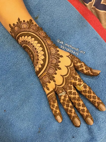 For engagements or other pre-wedding functions, an elegant back-of-hand design is a popular choice. This piece combines a central mandala with a delicate floral net pattern on the fingers for a sophisticated look.