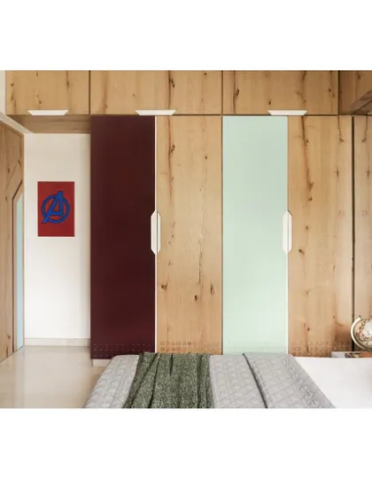 The wardrobe in the teenager's room features maroon and light blue panels, adding a touch of color to the knotty pine veneer.
