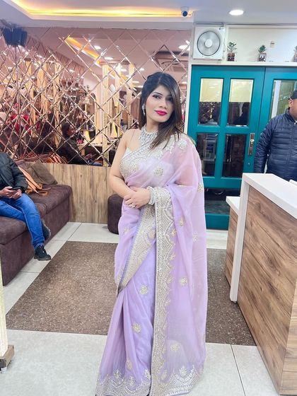 The full look, showing how the light and elegant saree is elevated by the glamorous makeup and hair.