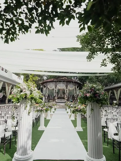 The main lawn set up for a large ceremony, with rows of chairs leading to the bandstand, showcasing a grand, Western-style wedding arrangement.
