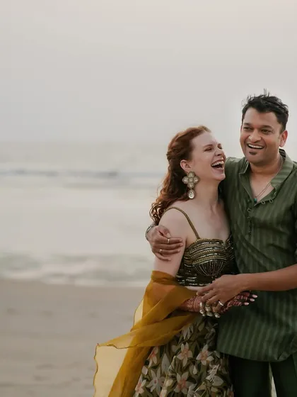 Capturing the easy, breezy vibe of a Goan sundowner. For Rach and Viraj's beach celebration, we chose earthy, tone-on-tone outfits. The bride's look was inspired by nature with a floral organza lehenga, while the groom wore a sheer olive green kurta, creating a relaxed yet chic couple style.