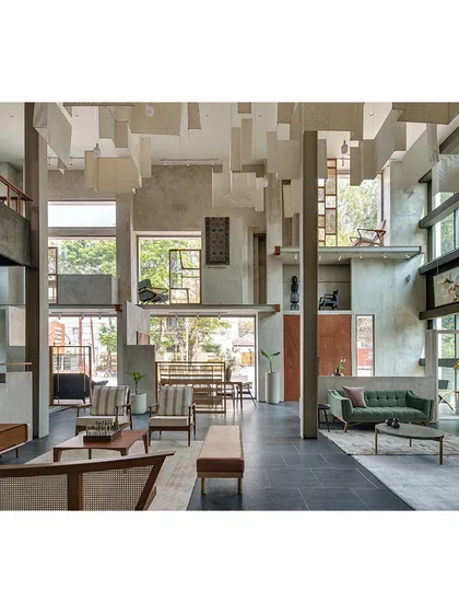 The interior of the Magari furniture store in Hyderabad was conceived as a multi-level experience. We used raw concrete and suspended fabric panels to define spaces without solid walls, allowing natural light from large windows to illuminate the craftsmanship of the furniture on display.