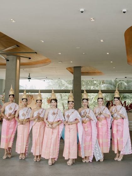A lineup of elegant Thai dancers in traditional pink and white attire, ready to welcome guests. Their grace and beauty add an authentic touch of Thai culture to the wedding.