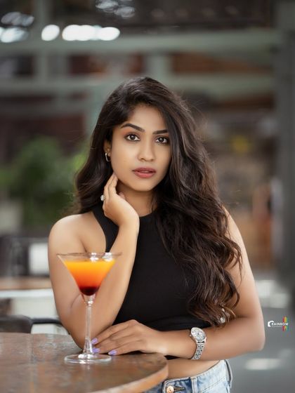 A variation from the cafe shoot with Pooja Ramesh, holding a drink, which adds a narrative element to the lifestyle portrait.