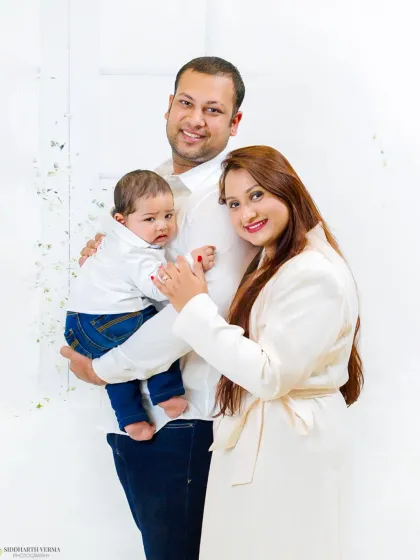 A classic family pose with parents and their newborn. This portrait beautifully captures the pride and love of a new family.