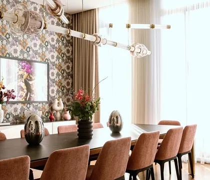 A custom configuration of the Luna Kaleido series in a dining room with bold wallpaper. The colored mouth-blown glass beads and metal finishes can be tailored to complement any interior palette.