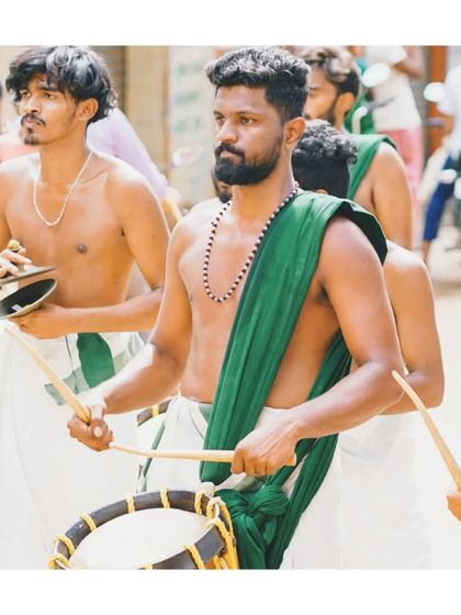 A moment of intense focus during a street procession. Each artist is locked into the rhythm, contributing to the powerful, unified sound of the melam.