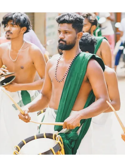 A moment of intense focus during a street procession. Each artist is locked into the rhythm, contributing to the powerful, unified sound of the melam.